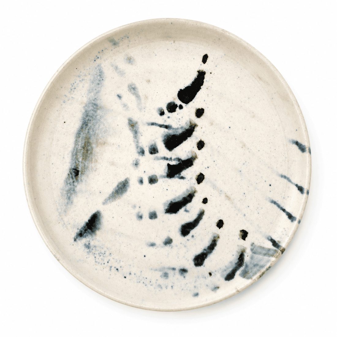 Assiette, éclaboussures bleu-gris sur fond crème